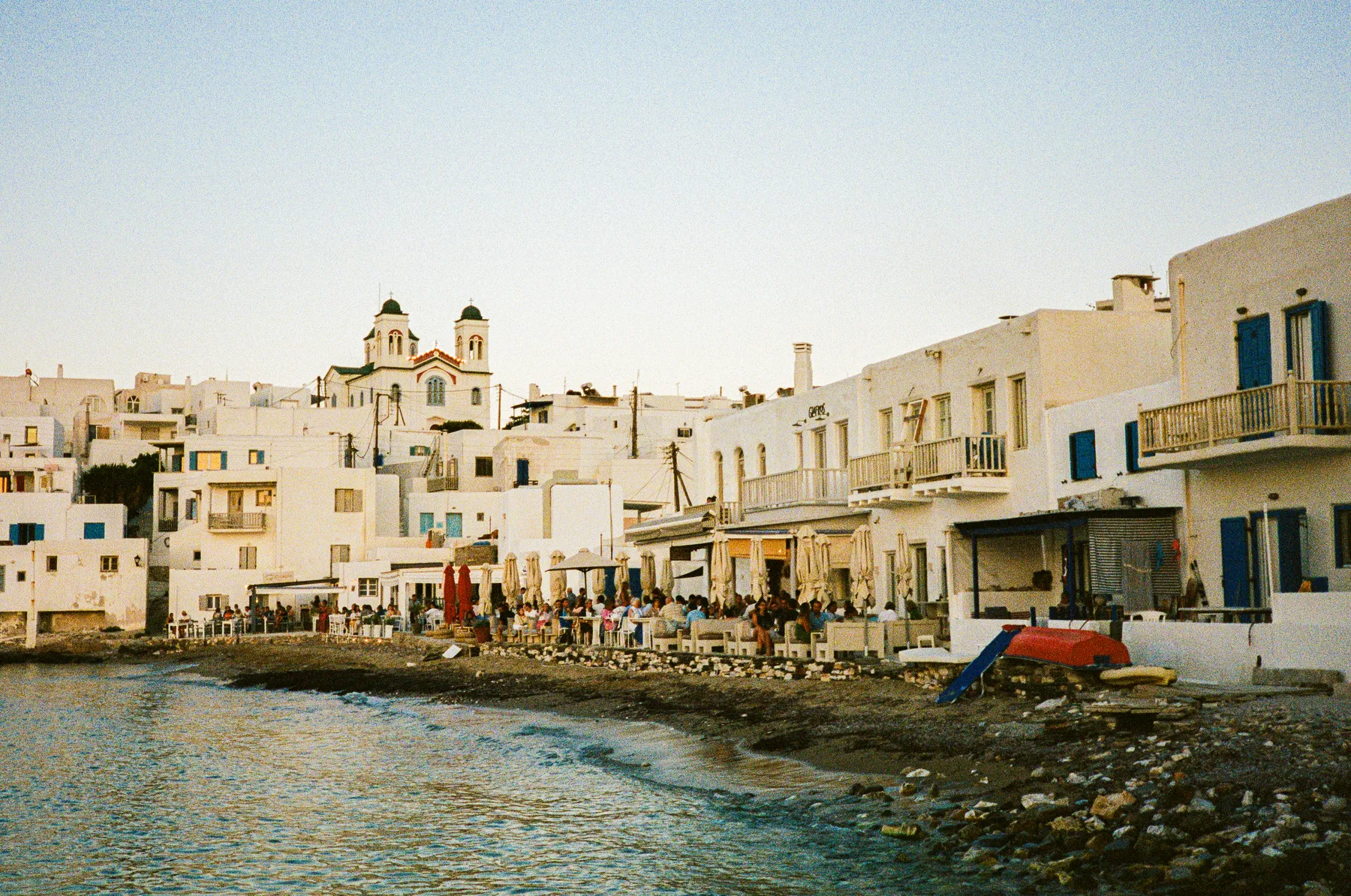 whitewashed houses and waterside tables at golden hour, naoussa, paros