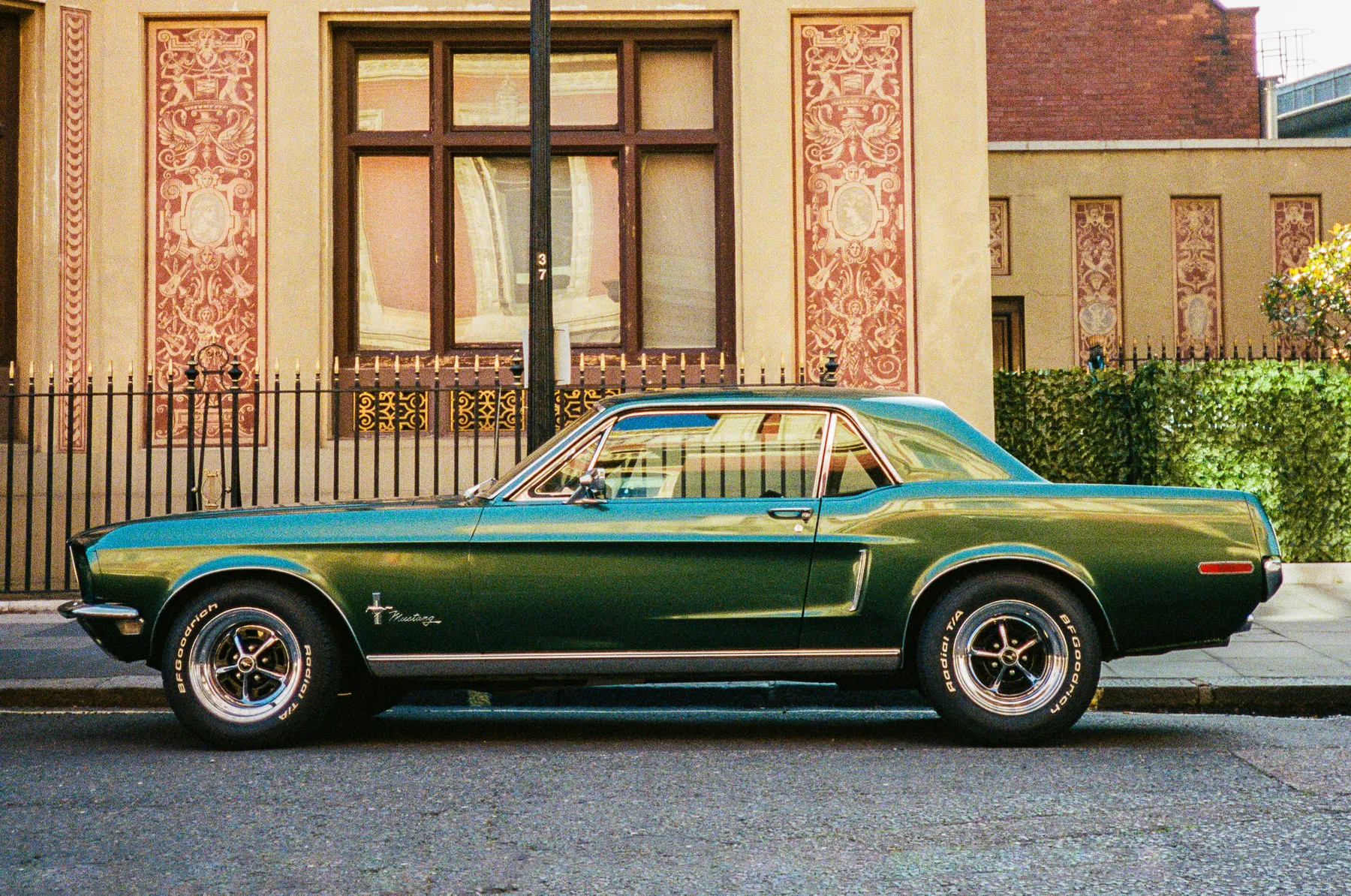 a racing green 1968 mustang parked on a london street